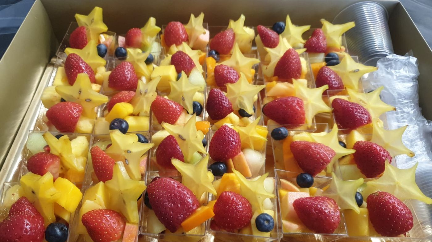 Fruit cups topped with star fruit, strawberries and blueberries